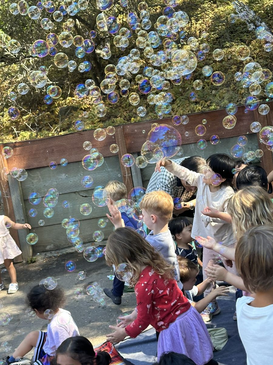 Children playing with bubbles outdoors at Butterflies Academy summer camp