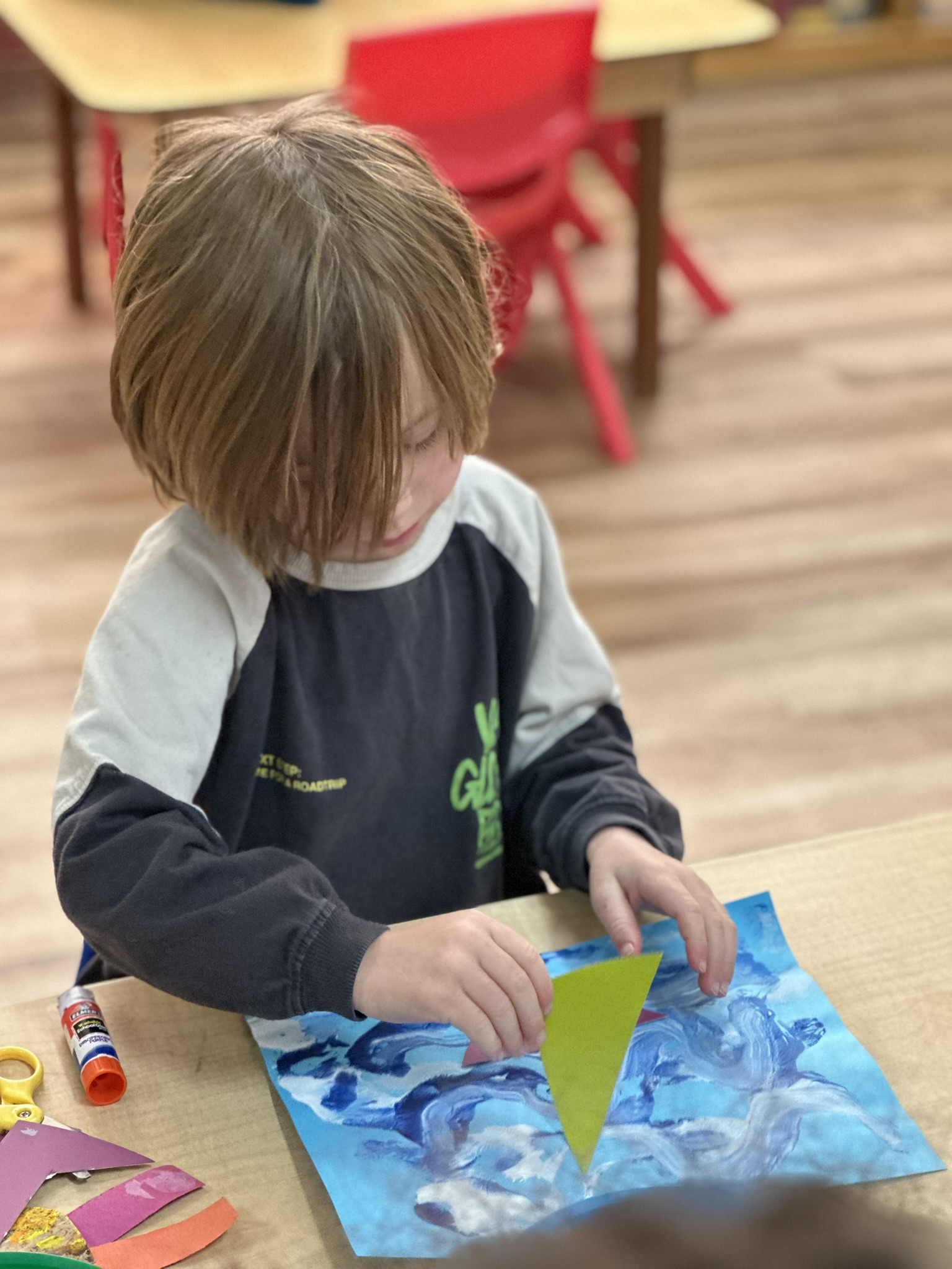 Volunteer helping a child with a craft at Butterflies Academy